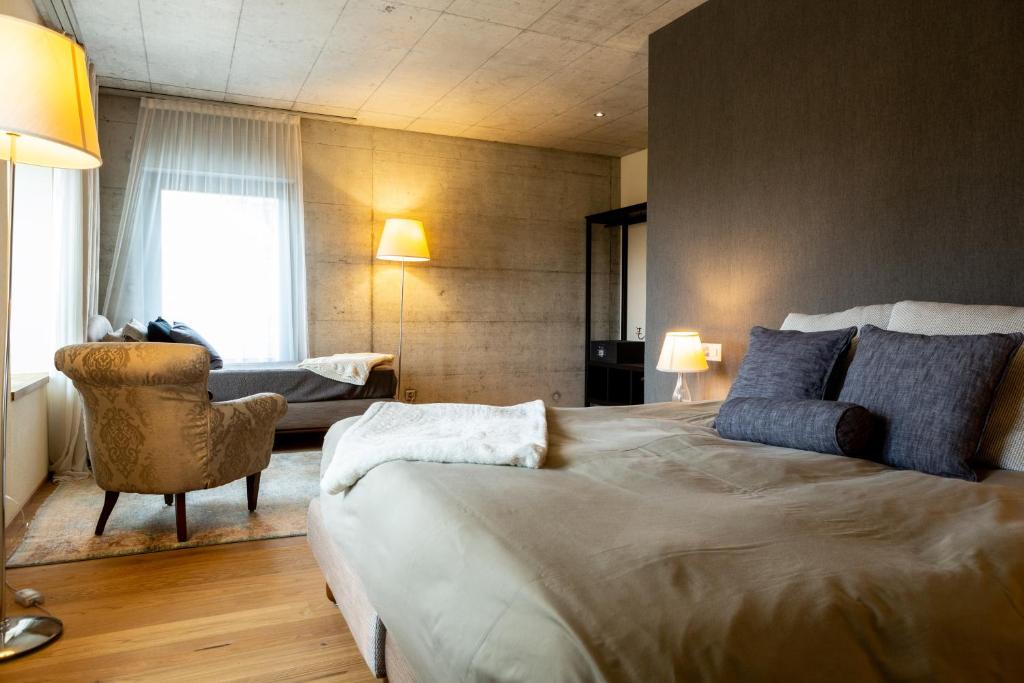 PrêlesHotel de l’Ours Preles的酒店客房带一张大床和一把椅子