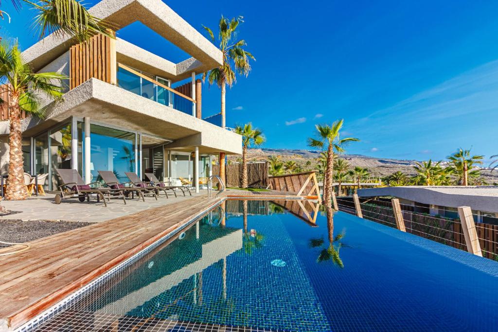 圣胡安海滩Villa Abama Belle Vue的一座带游泳池和棕榈树的房子