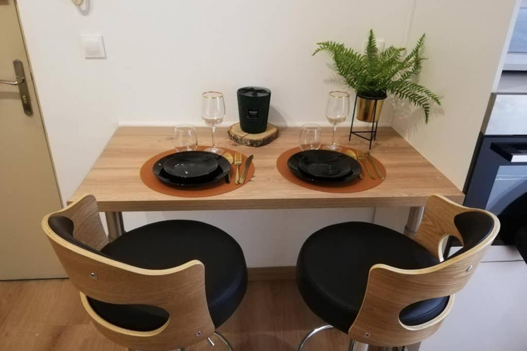 杜埃Escapades Douaisiennes的一张木桌,配有两把椅子和酒杯