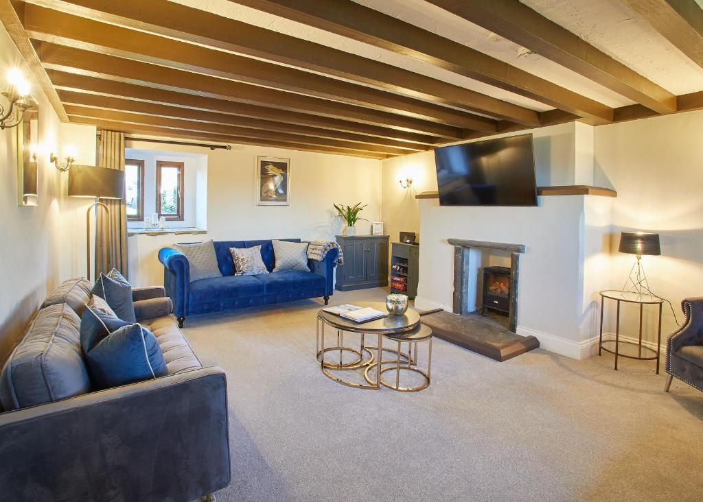 惠特比Host & Stay - The Coach House的客厅设有蓝色的沙发和壁炉