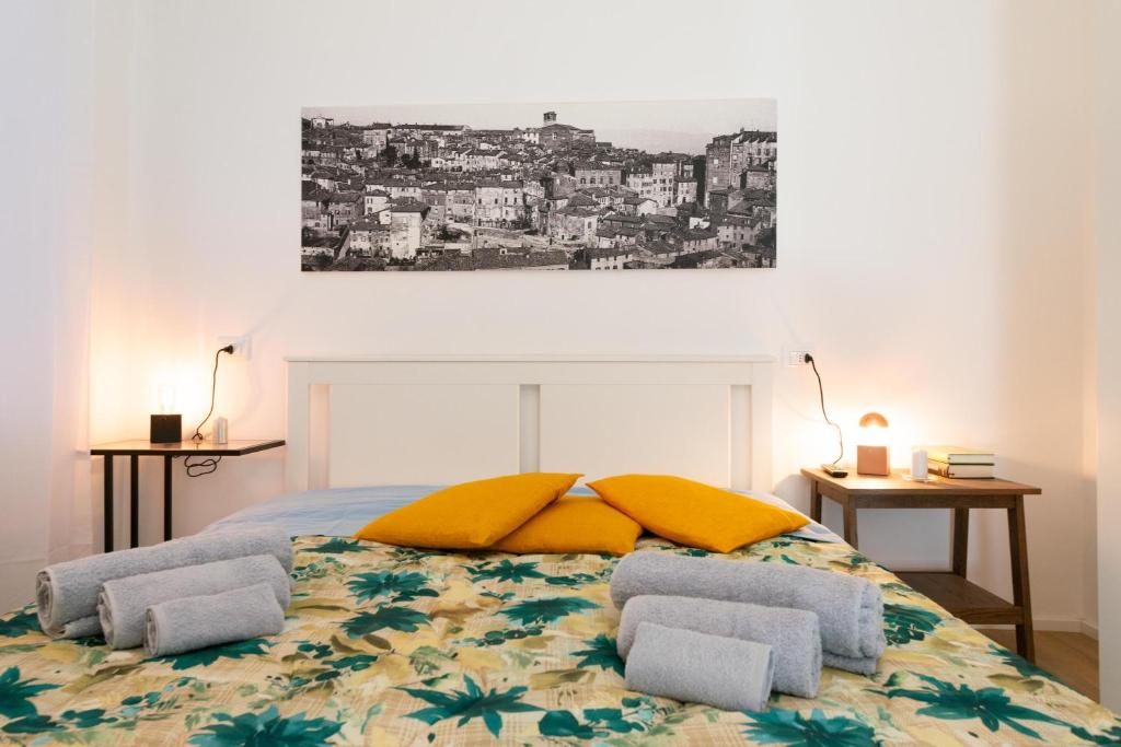 佩鲁贾PINTURICCHIO Guest House的一间卧室配有一张带两个黄色枕头的床