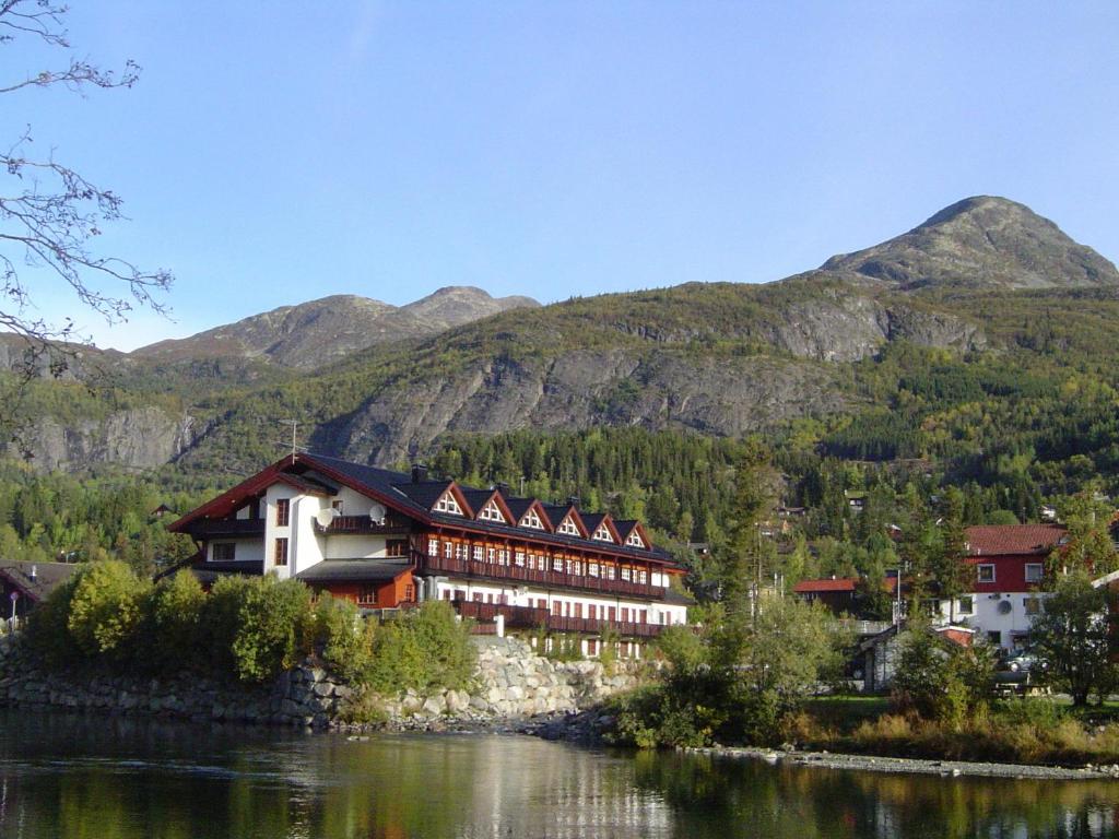 海姆瑟达尔法妮土伦酒店的一座建筑,毗邻一条以山为背景的河流