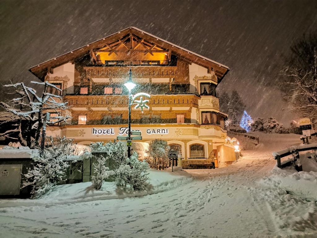 伊施格尔Hotel Garni Apart TINA的一座大建筑物,在晚上下雪