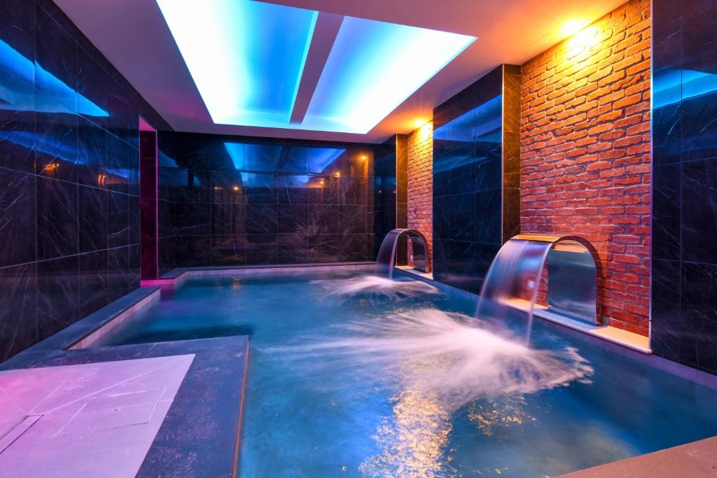 布雷西亚马斯特酒店的客房内的按摩浴缸和瀑布