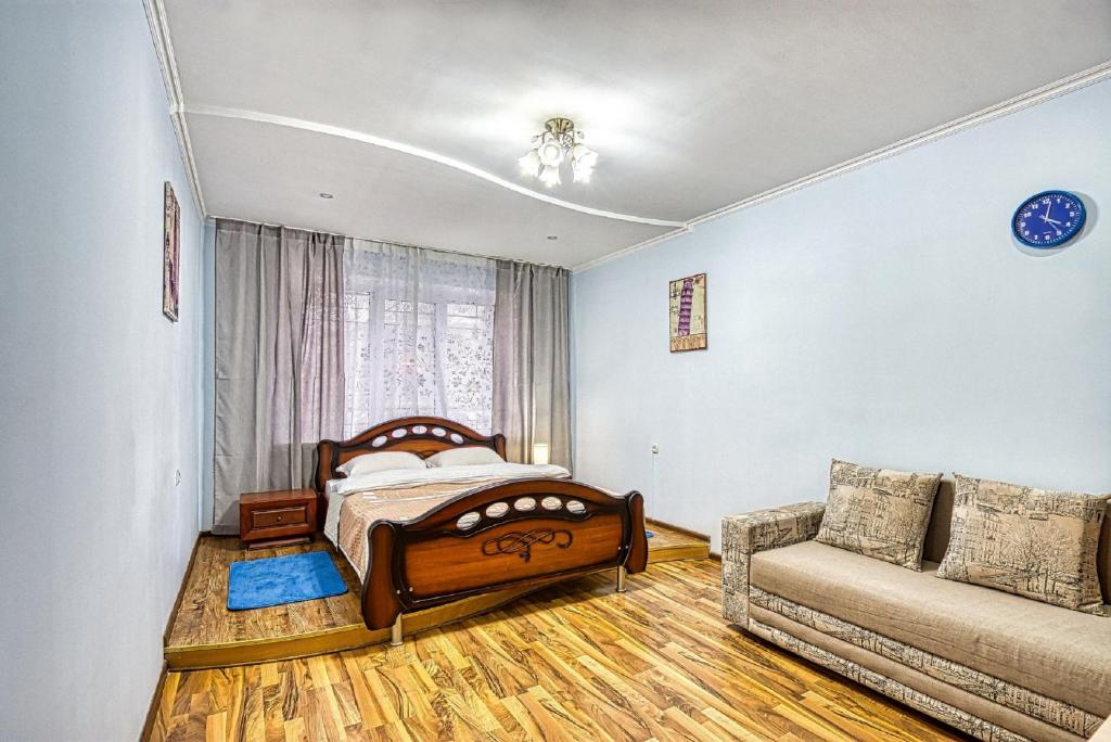 阿拉木图Апартаменты Орбита-2, 11的一间卧室配有一张床和一张沙发