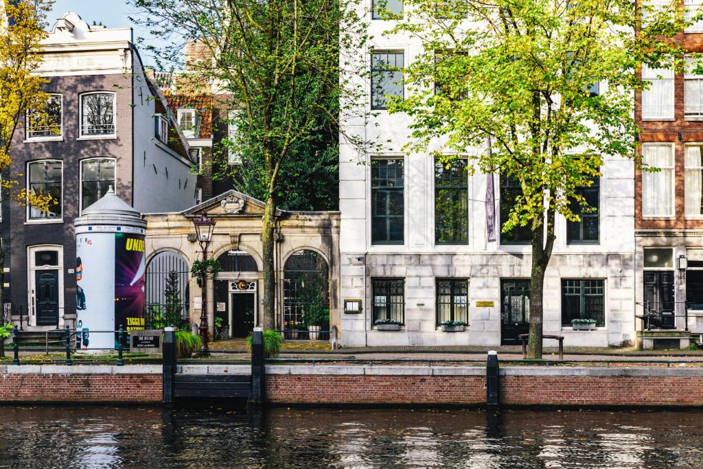 阿姆斯特丹The Dylan Amsterdam - The Leading Hotels of the World的河岸边的建筑物,有建筑物
