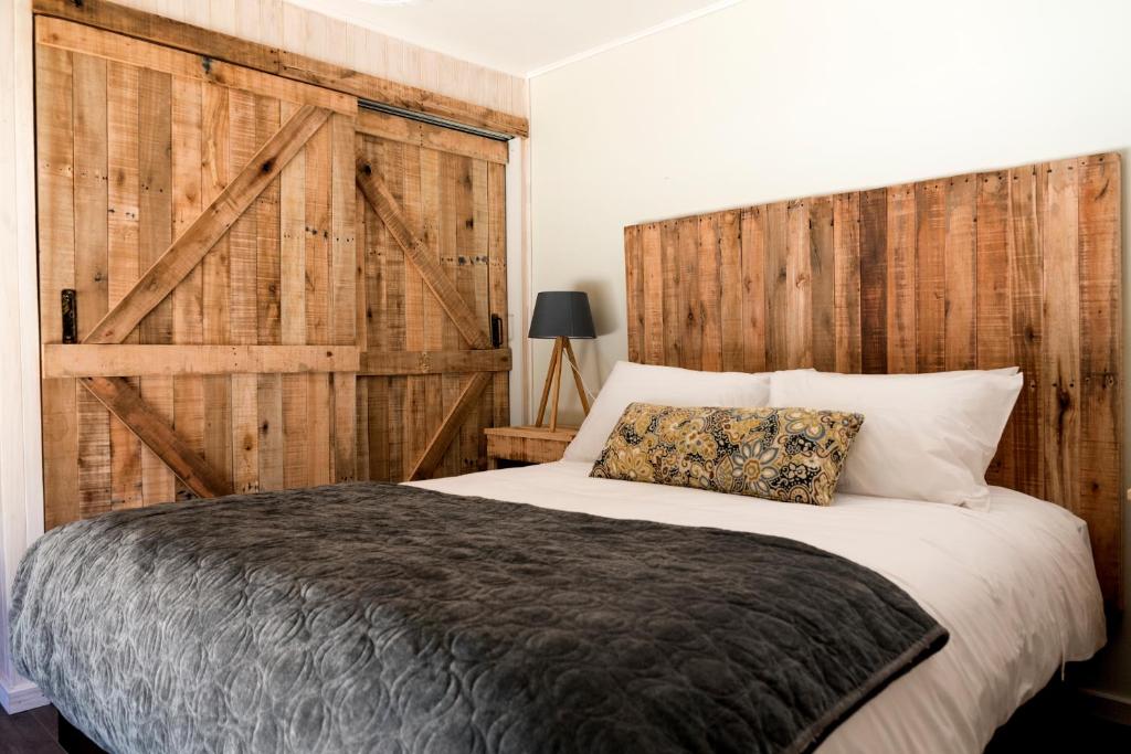 马拉卡韦罗Cabañas Los Huemules的一间卧室设有一张带木墙的大床