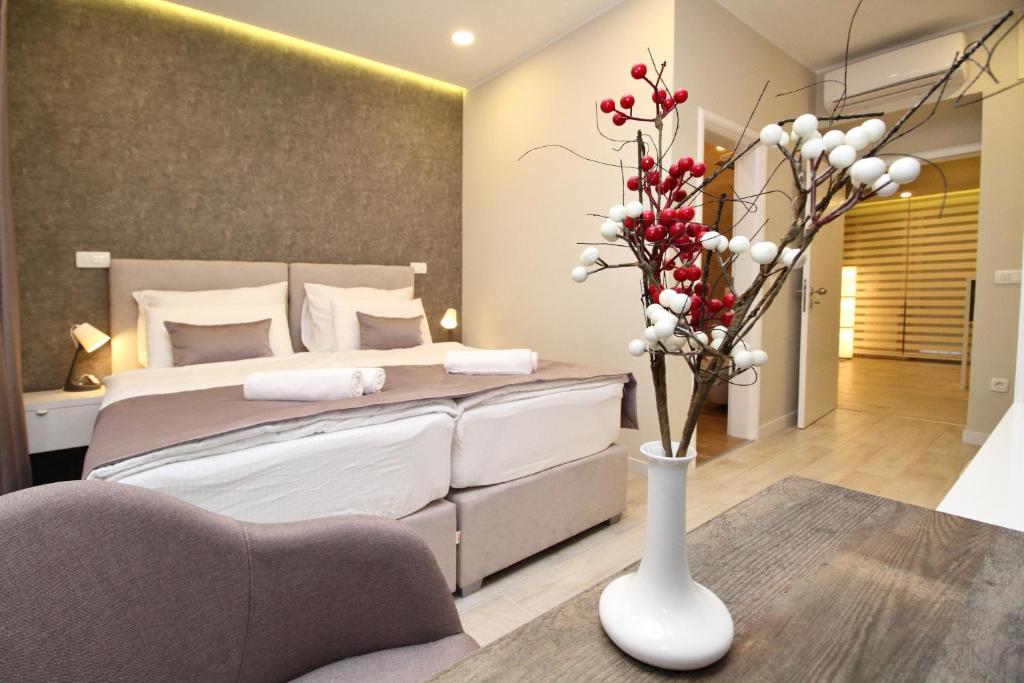 萨拉热窝PLATINUM ROOMS butique hotel的一间卧室配有床和花瓶