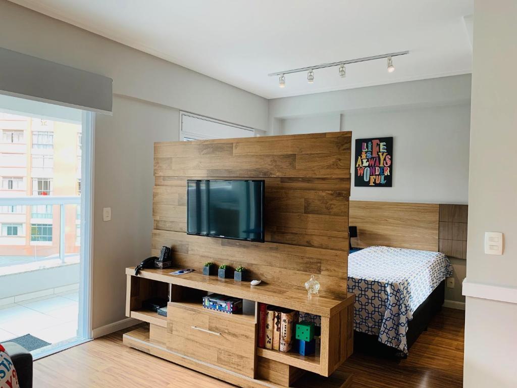 圣保罗CS Apartamento a 200 metros da Paulista com AC的一间卧室设有大木墙和平面电视