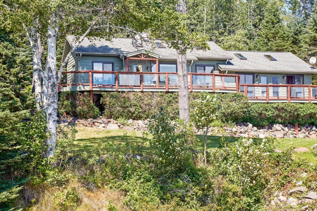 SchroederHeart of Superior Lake Cabin 15 Mi to Lutsen Mtn!的树林中带甲板的房子