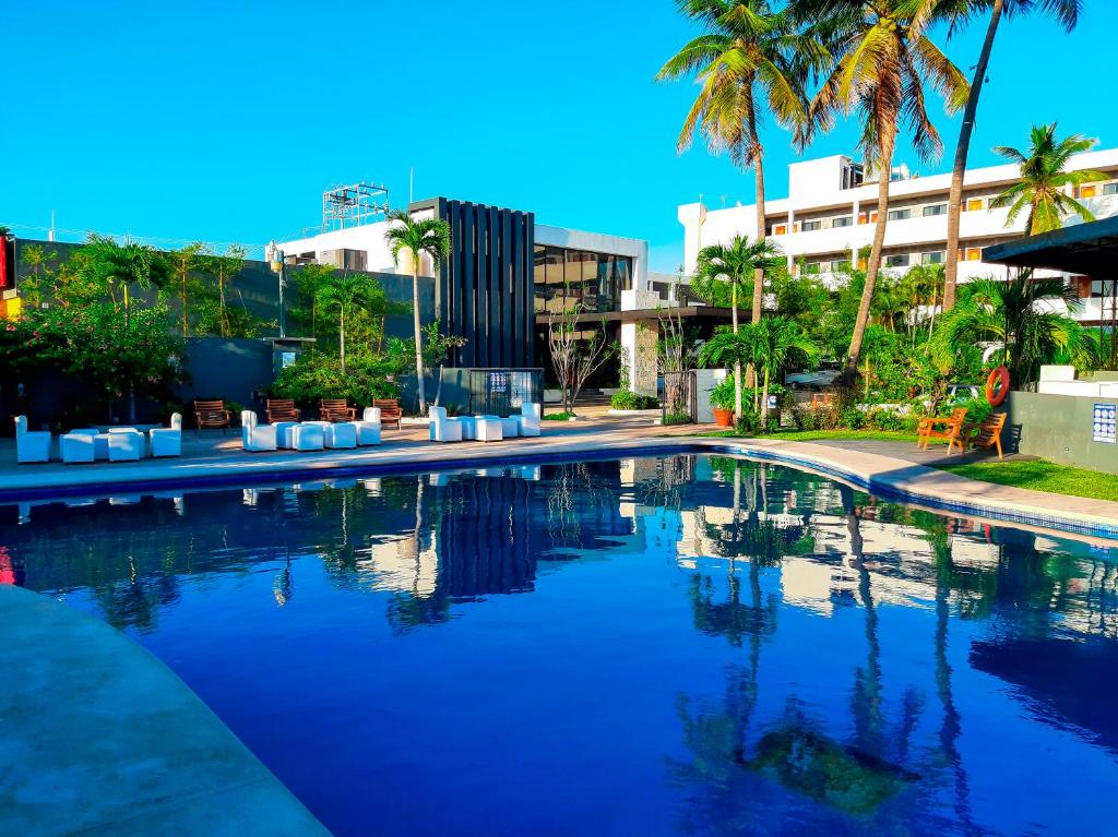 坦皮科圣安东尼奥酒店的一座棕榈树游泳池和一座建筑