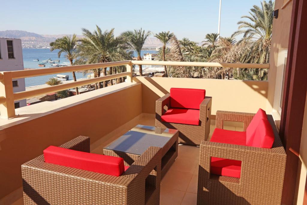 亚喀巴La Riva Hotel的一个带椅子的阳台,享有海滩美景