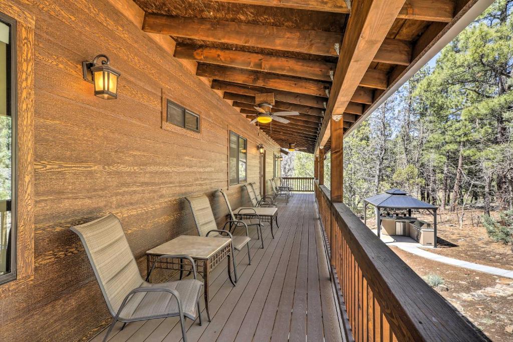 派托普湖畔Spacious Pinetop-Lakeside Home with Hot Tub on 1 Acre的门廊配有椅子和桌子