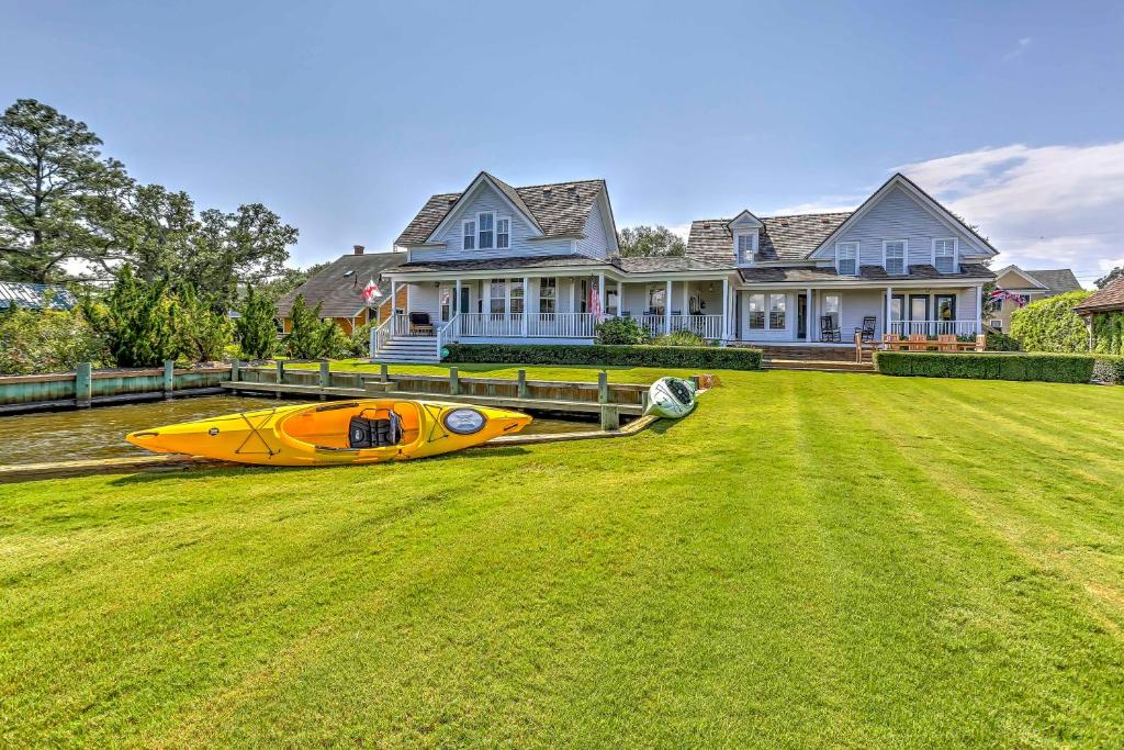 曼蒂奥Historic Manteo House on Roanoke Sound with Dock!的坐在房子前面的草上的一个黄色小船