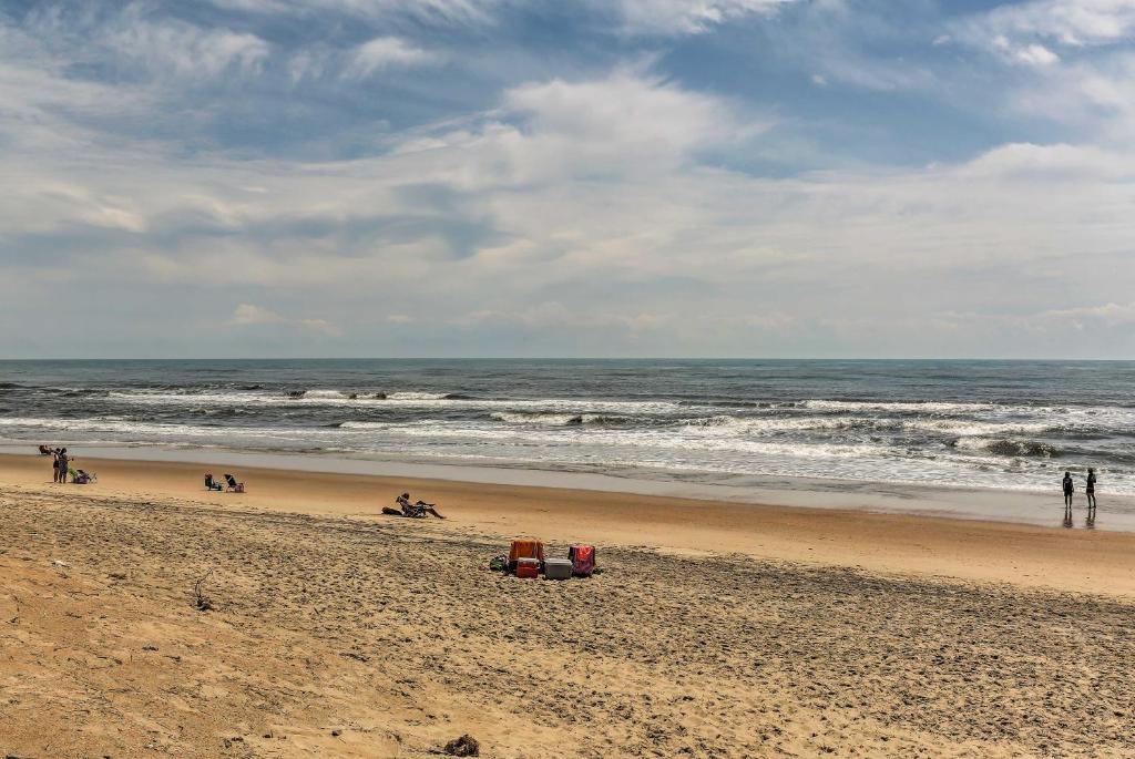 FriscoOuter Banks Island Cottage - 1 Mi to Frisco Beach!的一群人与大海的海滩