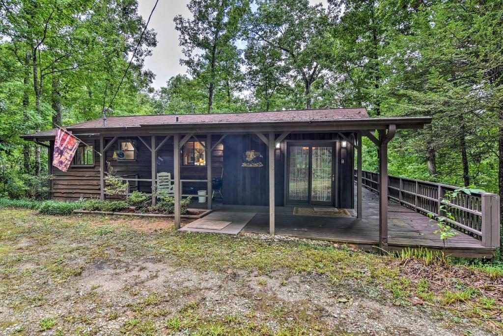 罗宾斯维尔Robbinsville Cabin with Deck 3 Mi to Fontana Lake!的树林中的一个小屋,设有门廊