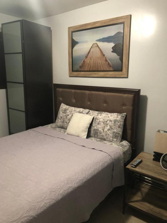 布鲁克林Brooklyn's Finest - Cozy 2 Bedroom的卧室配有一张床,墙上挂着一幅画