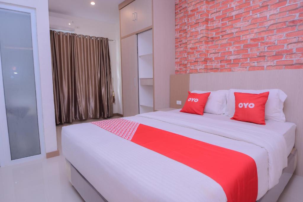班达亚齐SUPER OYO Capital O 2018 Ring Road Guest House Syariah的一间卧室配有一张大床和两个红色枕头