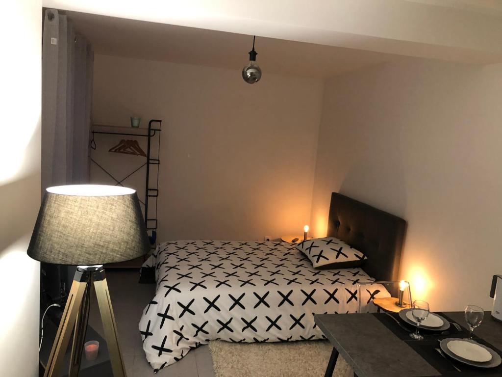 芒特拉若利Studio 104的一间卧室配有一张床、一张桌子和一盏灯
