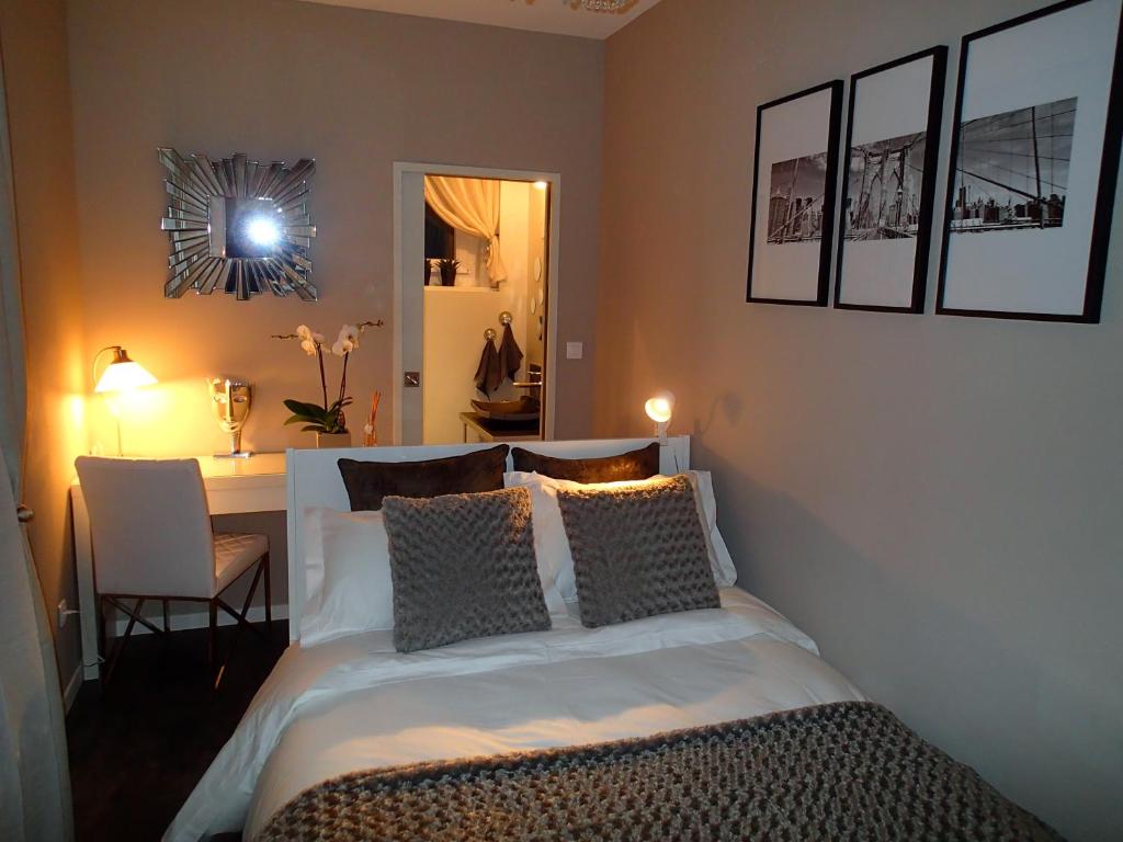 拉马德莱娜新西室酒店的一间卧室配有一张床、一张书桌和一面镜子