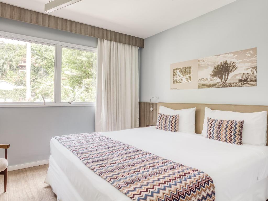 贝洛奥里藏特CHA Pampulha Design Hotel的一间卧室设有一张大床和一个窗户。