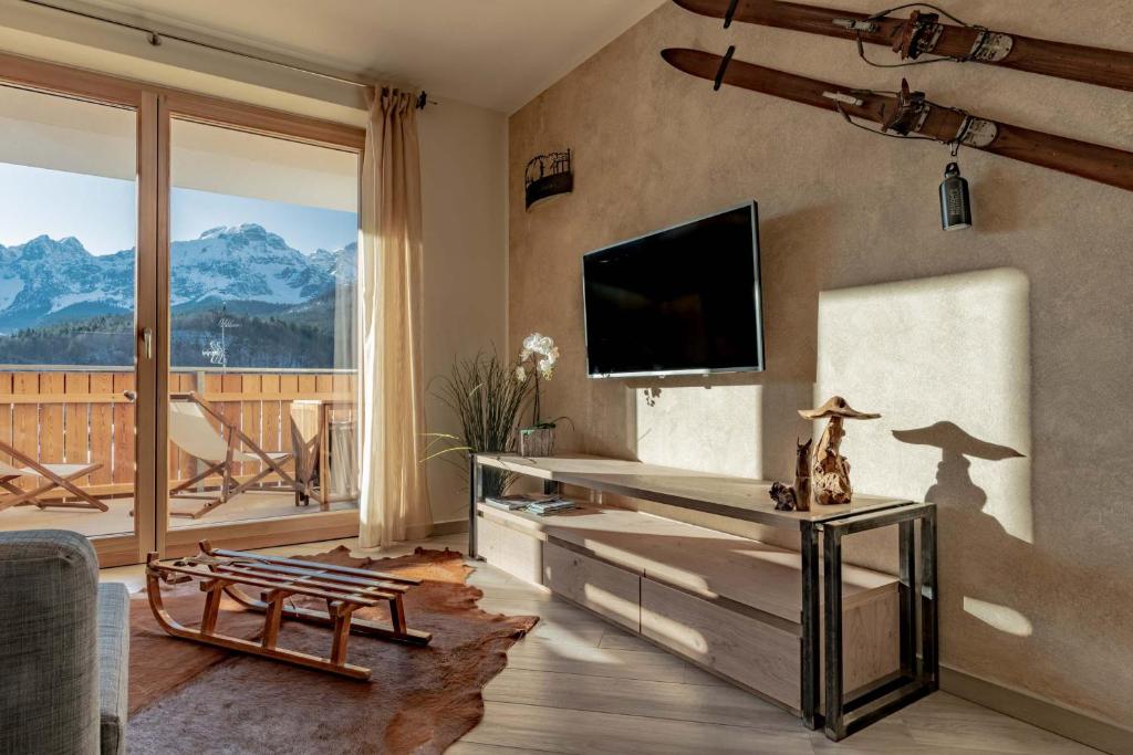 安达洛Appartamento Lusso Panoramic - Andalo的客厅设有壁挂式平面电视。