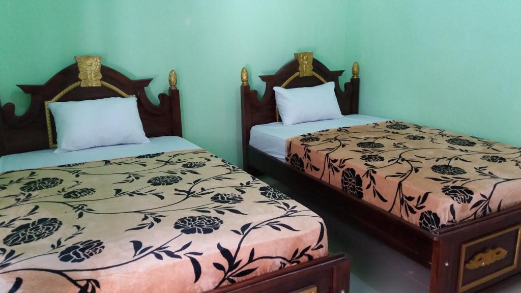 庞越Hotel Surya Utama - Syariah的两张睡床彼此相邻,位于一个房间里
