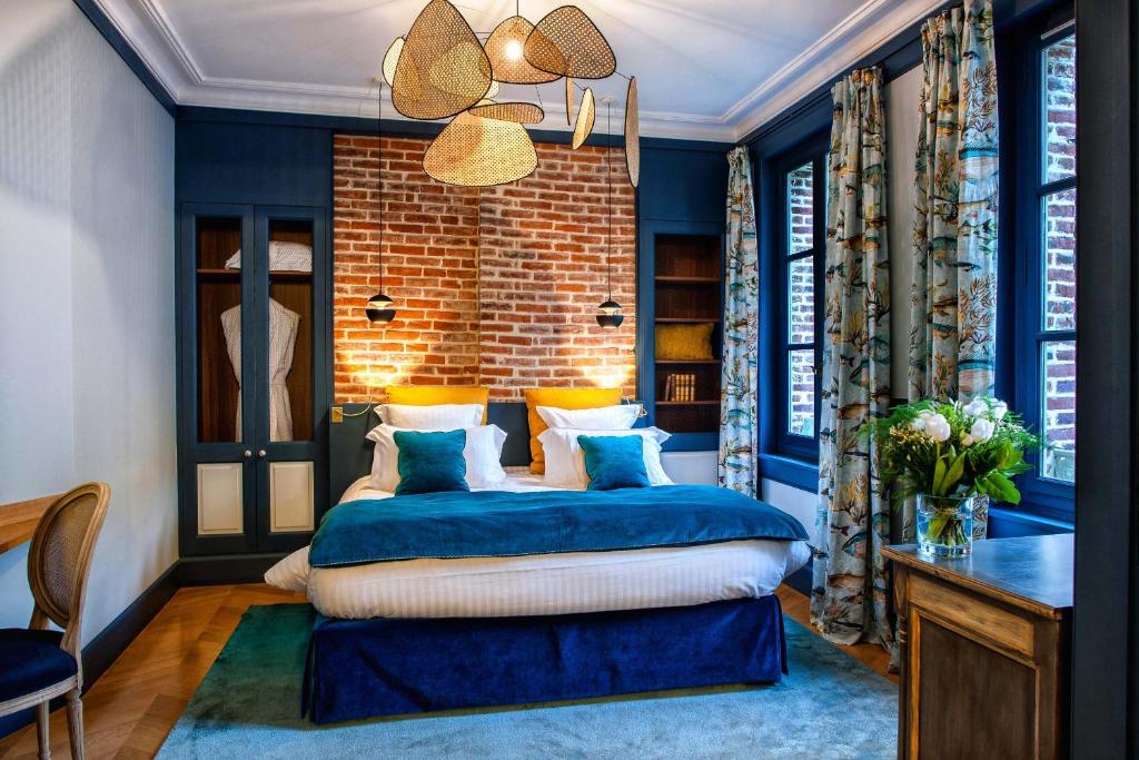 翁弗勒尔拉皮提特佛利酒店的一间拥有蓝色墙壁的卧室和一张位于客房内的床