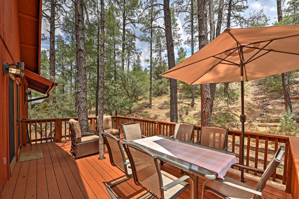 普雷斯科特Prescott Cabin with Beautiful Forest Views and Deck!的木甲板配有桌子和遮阳伞