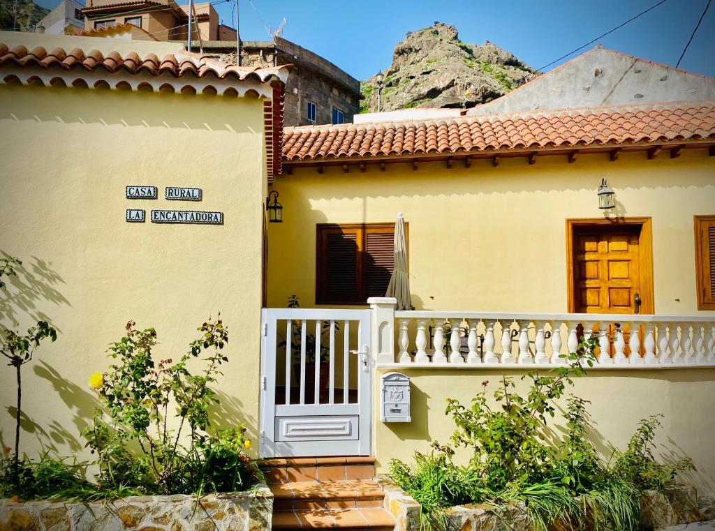 巴列埃尔莫索Casa rural La Encantadora的黄色的房子,设有白色的大门和阳台