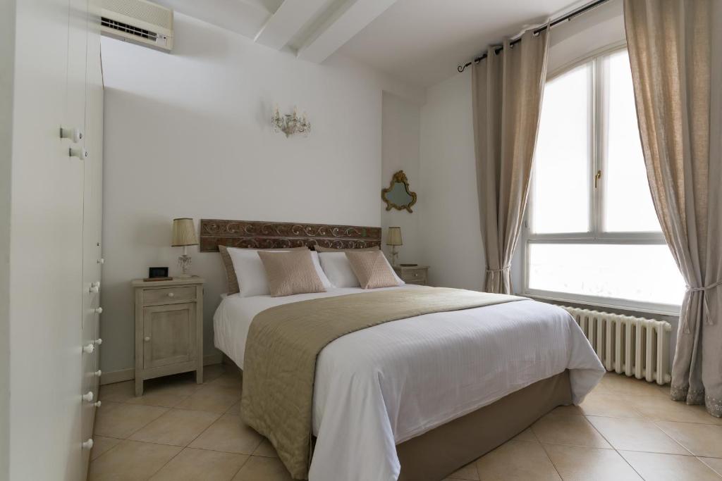 博洛尼亚莱蒂齐亚公寓的白色的卧室设有一张大床和一个窗户
