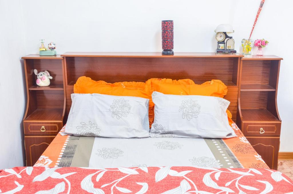 舍曼格勒涅La Caverna House的一张带橙色和白色枕头的床