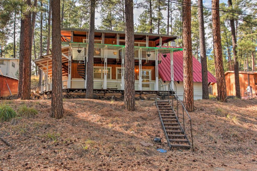 鲁伊多索Ruidoso Cabin with Forest Views and Covered Porch的树林中一座红色屋顶的房子