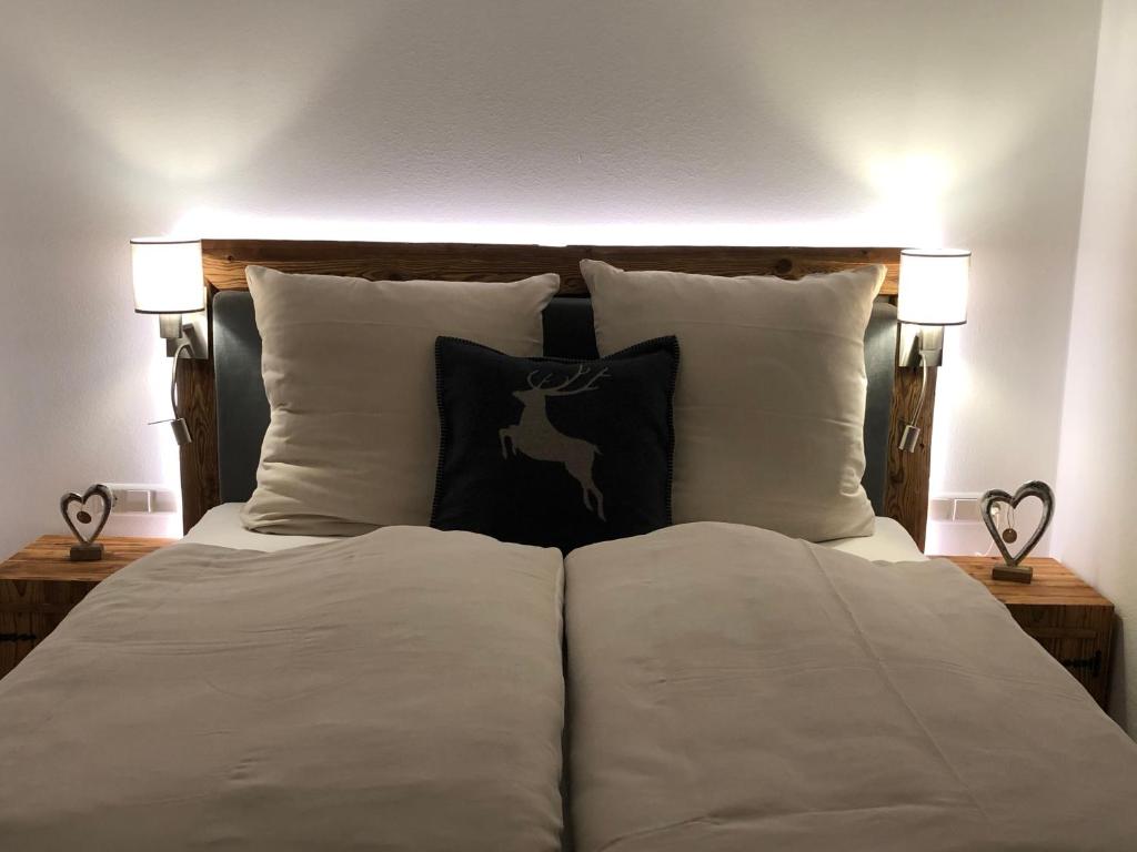 雷特温克尔Ferienwohnung Winklblick的两边配有白色枕头和两盏灯的床