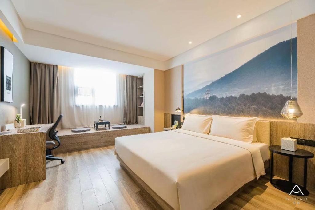 杭州杭州湖墅南路亚朵酒店的酒店客房设有一张大床和一张书桌。