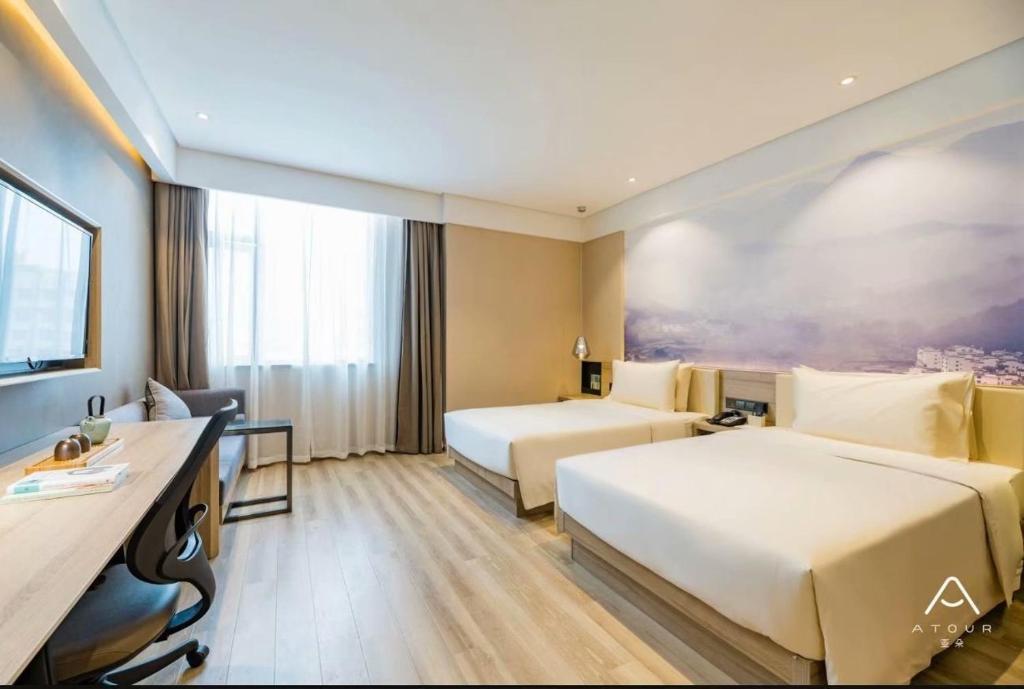 西安西安大寨路亚朵酒店的酒店客房配有两张床和一张书桌
