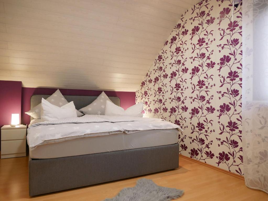 马尔贝格Ferienwohnung Eva-Maria的一间卧室配有一张带花卉壁纸的大床