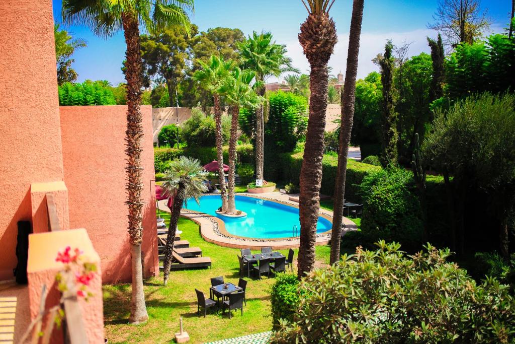 马拉喀什红房子酒店的棕榈树庭院内游泳池的顶部景色