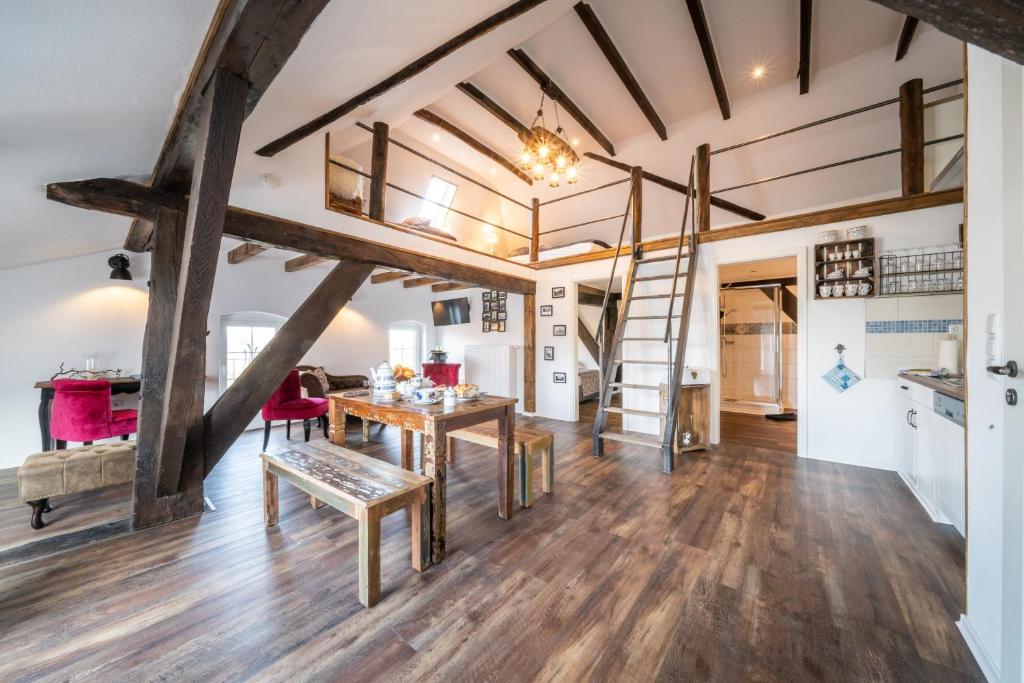 博尔库姆Ostland-Loft的铺有木地板的客厅和带梯子的阁楼
