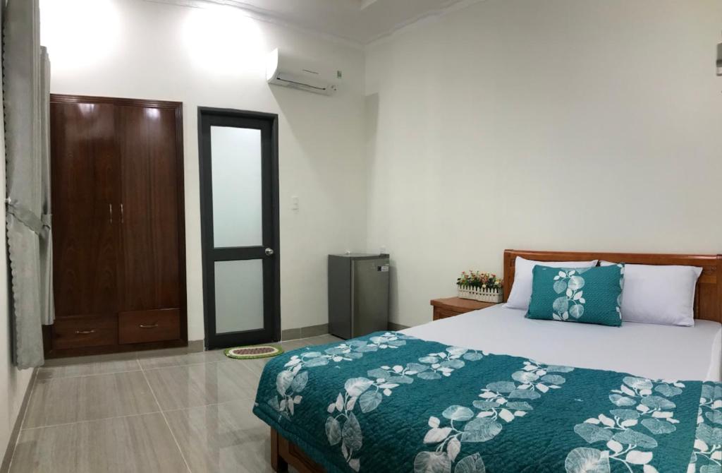 头顿Motel Thân Thiện 2的一间卧室配有一张带绿床罩的床