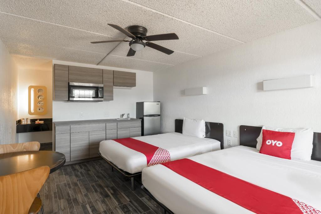 休斯顿OYO Hotel Houston Katy Freeway的酒店客房配有两张床和吊扇。