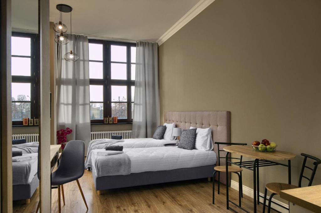 埃尔布隆格Apartamenty Oliwka的一间卧室配有两张床和一张桌子