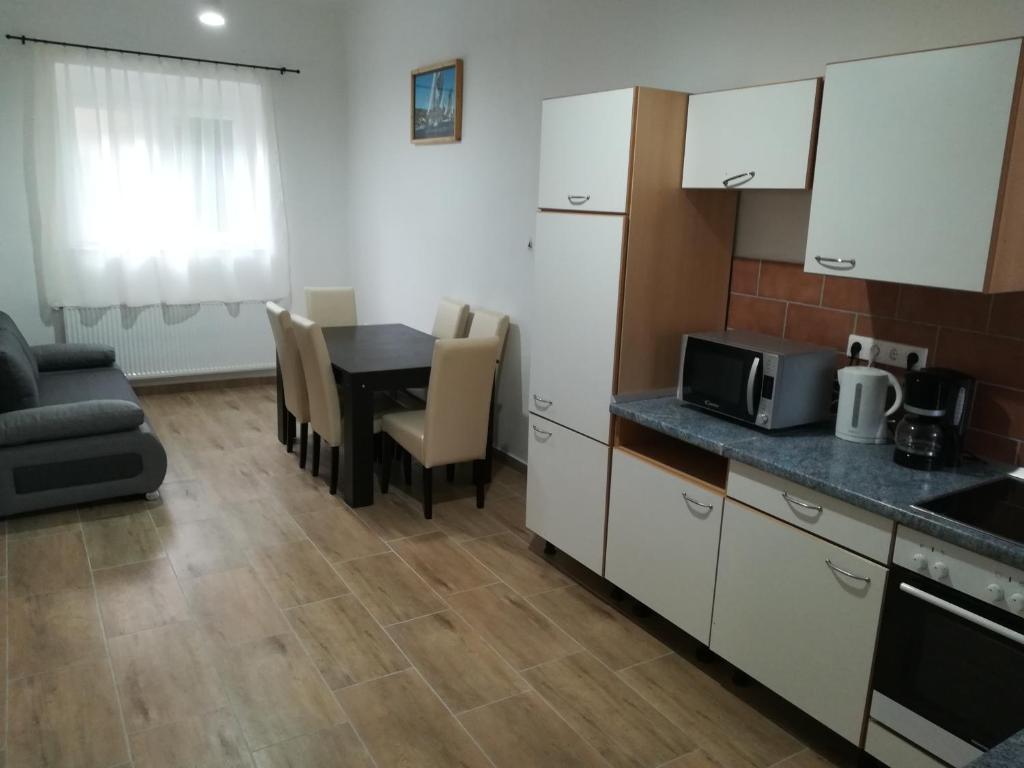 许迈格Sümegi Levendula Apartmanok的厨房以及带桌子和微波炉的客厅。