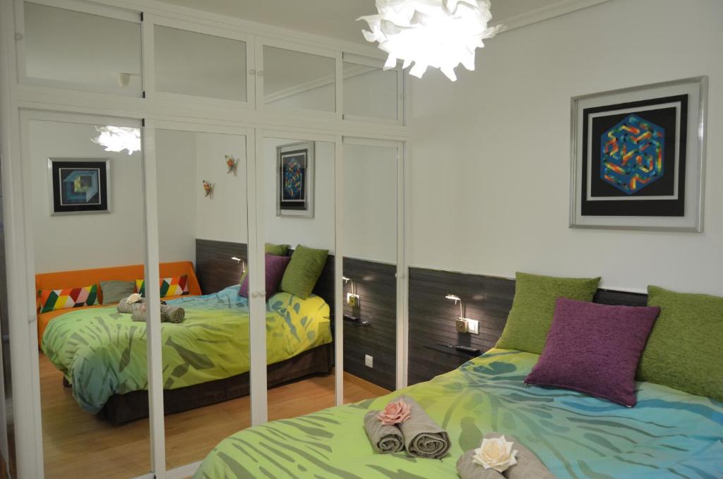 塞维利亚SEVILLA-TRIANA的一间卧室配有两张床和镜子