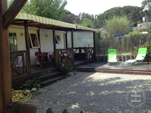 圣特罗佩Mobilhome sur camping le kontiki **** ramatuelle的房屋设有2把椅子和1张桌子