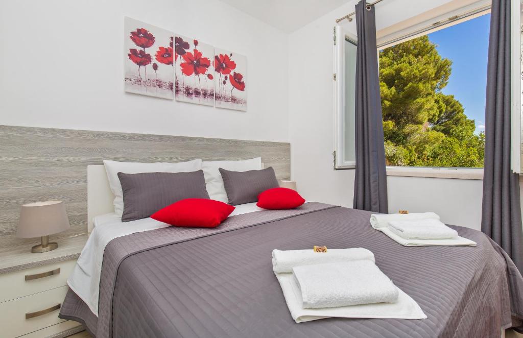索布拉Apartments More的一间卧室配有一张带红色枕头的床和一扇窗户
