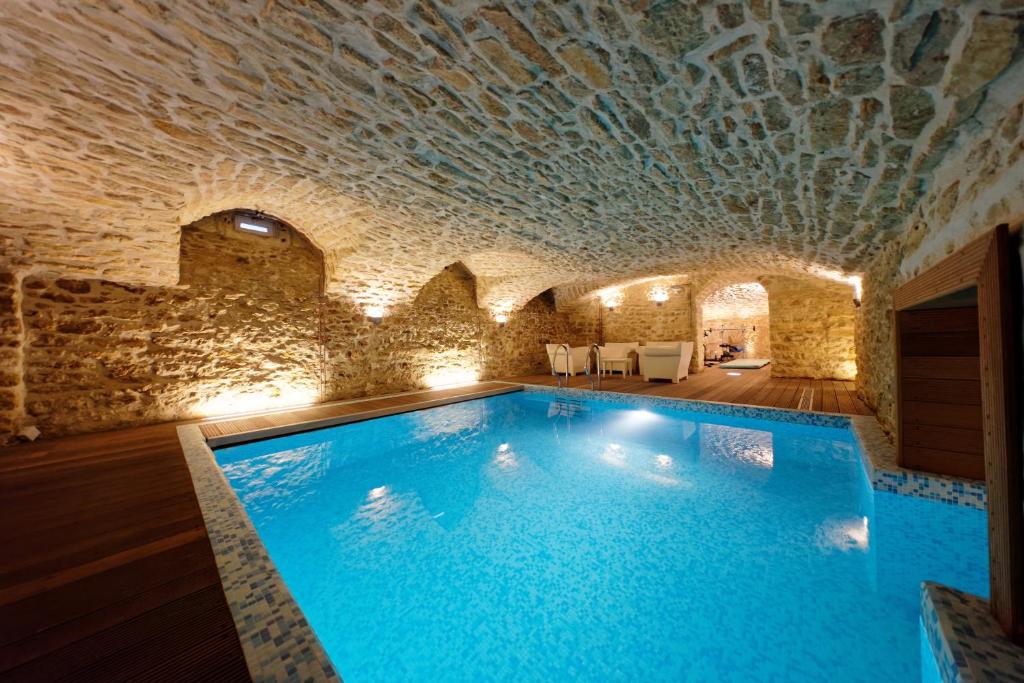 勒芒L'HOTEL PARTICULIER - LE MANS的一座石头天花板建筑中的游泳池