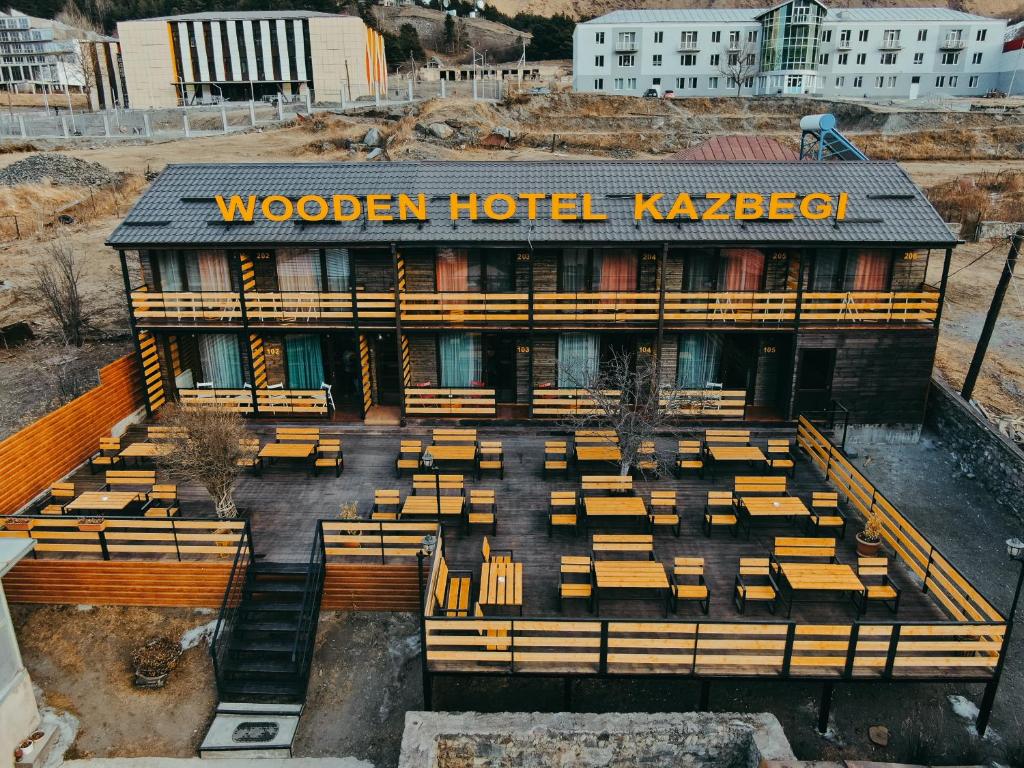 卡兹贝吉Wooden Hotel Kazbegi的一间木制酒店,前面设有长椅