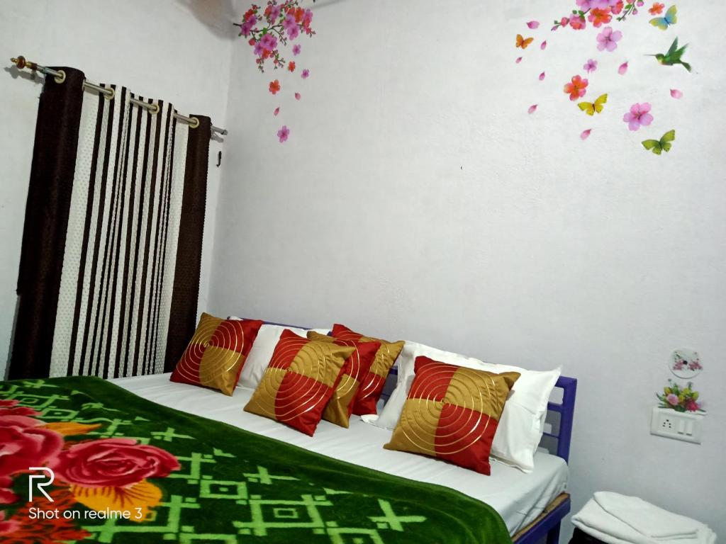 克久拉霍Khajuraho Dreams Homestay的一间卧室配有带色彩缤纷的枕头和鲜花的床。