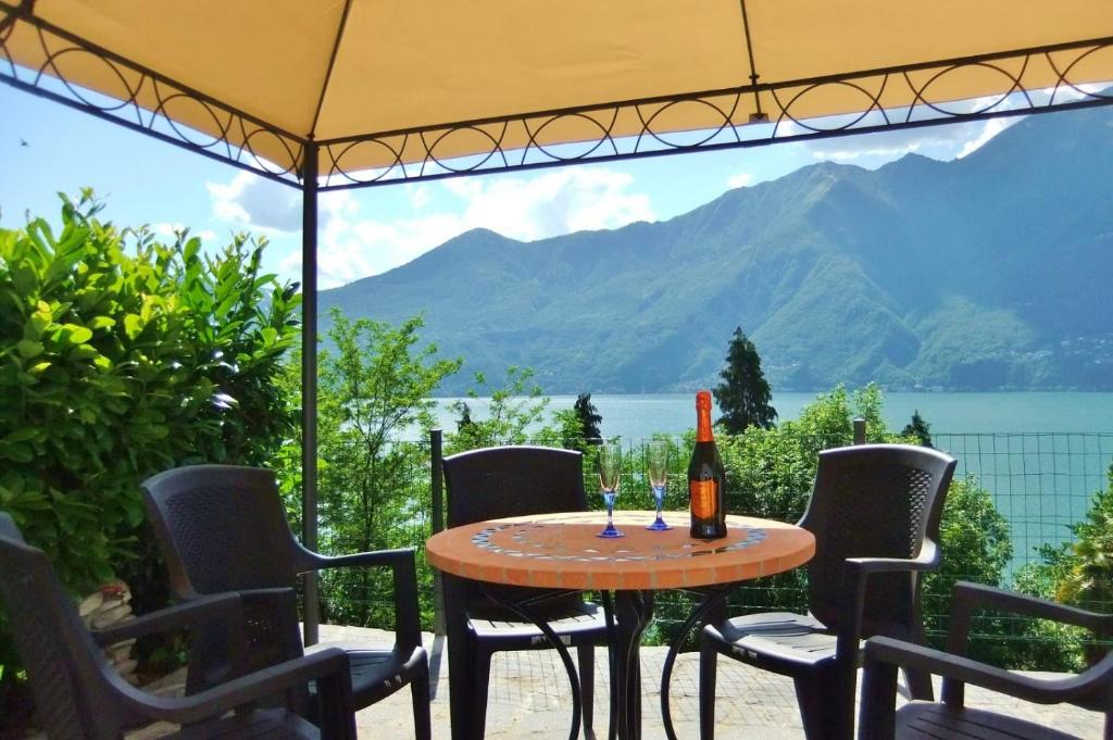 Pino Lago MaggioreCasa le Palme的桌椅和一瓶葡萄酒